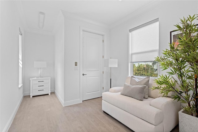 living area featuring light hardwood / wood-style flooring and ornamental molding