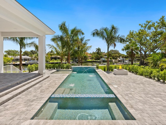 view of pool with a patio area, a water view, and pool water feature