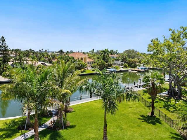 view of home's community with a water view and a lawn