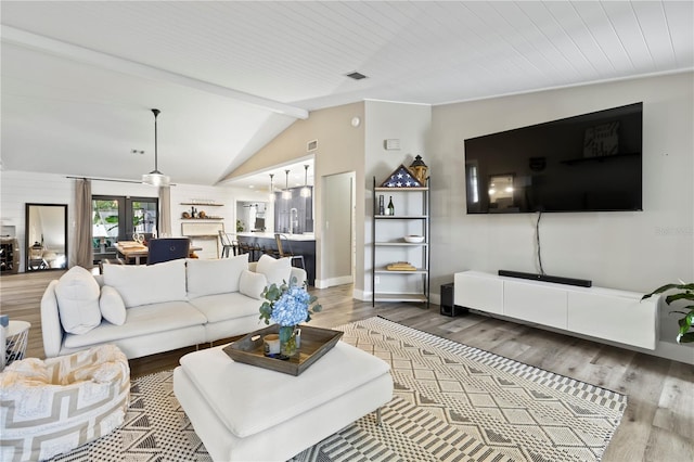 living room with lofted ceiling with beams and hardwood / wood-style floors