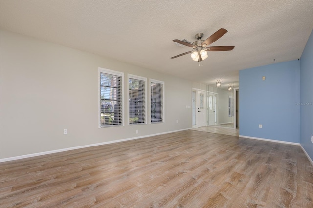 empty room featuring ceiling fan, a textured ceiling, and light hardwood / wood-style flooring