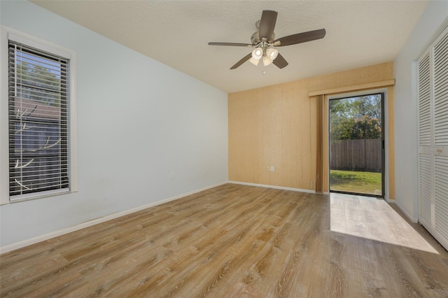 spare room with ceiling fan, light hardwood / wood-style floors, and a textured ceiling