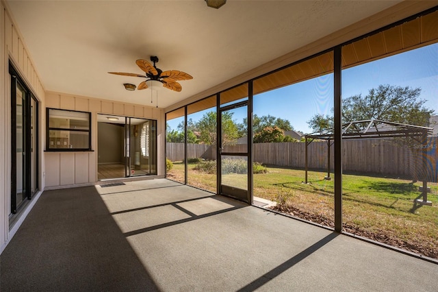 unfurnished sunroom featuring ceiling fan