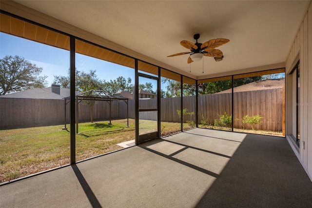 unfurnished sunroom with ceiling fan