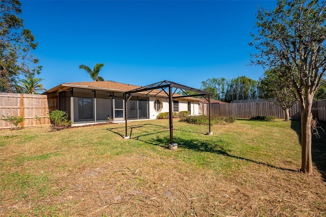 rear view of house with a yard and a sunroom