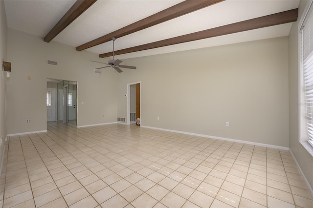 tiled empty room featuring ceiling fan and beam ceiling