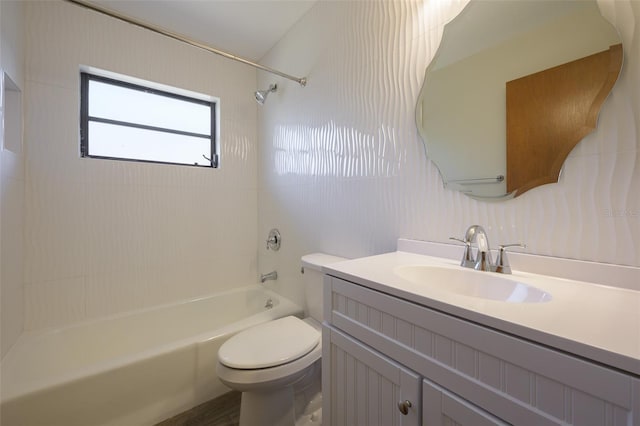 full bathroom featuring tiled shower / bath combo, toilet, and vanity