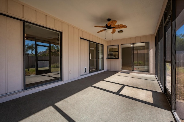 unfurnished sunroom with ceiling fan