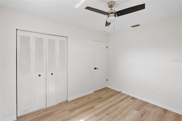 unfurnished bedroom featuring ceiling fan, a closet, and light hardwood / wood-style flooring