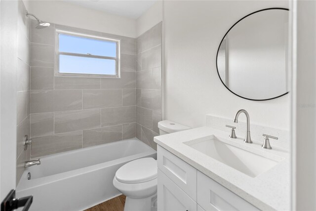 full bathroom with hardwood / wood-style floors, vanity, toilet, and tiled shower / bath combo