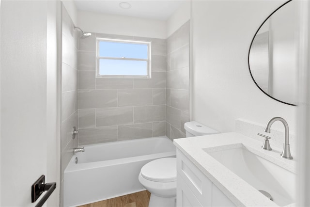 full bathroom with tiled shower / bath, toilet, vanity, and hardwood / wood-style flooring