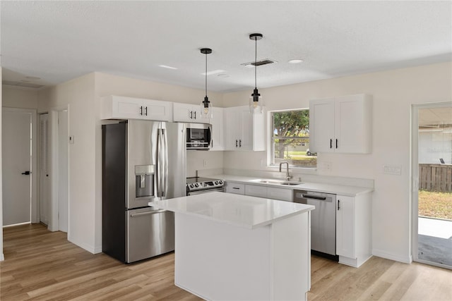 kitchen featuring white cabinets, sink, light hardwood / wood-style floors, a kitchen island, and stainless steel appliances