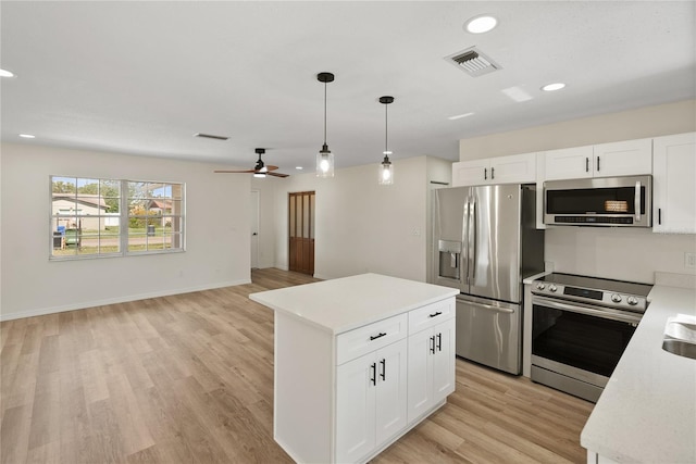 kitchen with white cabinets, light wood-type flooring, and appliances with stainless steel finishes