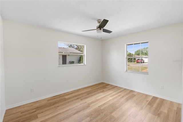 empty room featuring ceiling fan, light hardwood / wood-style flooring, and a textured ceiling