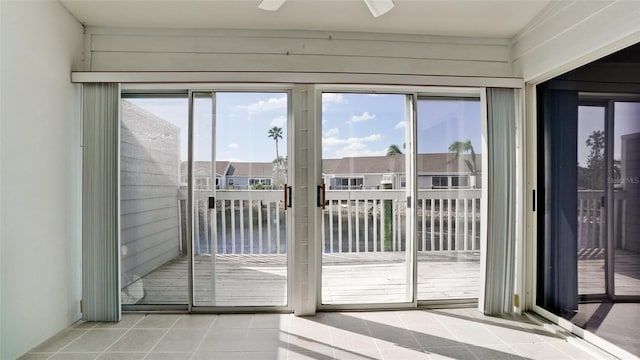 entryway with plenty of natural light, light tile patterned flooring, and ceiling fan