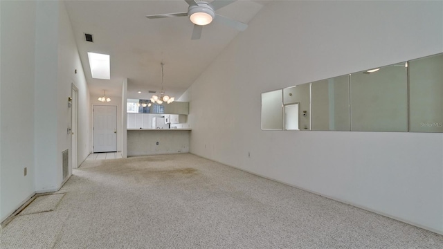 spare room featuring light colored carpet, ceiling fan with notable chandelier, and high vaulted ceiling