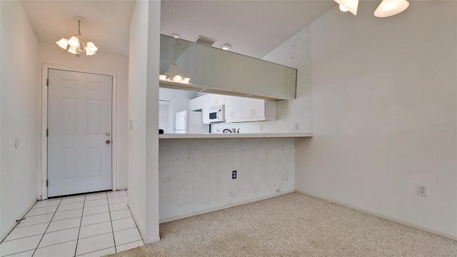 kitchen featuring light colored carpet, lofted ceiling, white appliances, and an inviting chandelier