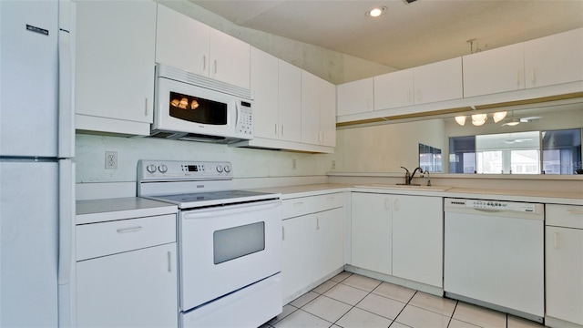 kitchen featuring white cabinets, white appliances, light tile patterned floors, and sink