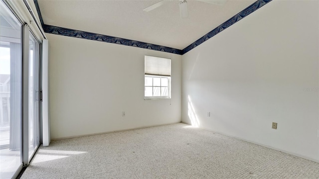 empty room featuring a textured ceiling, light carpet, and ceiling fan