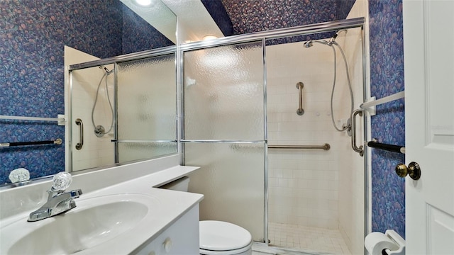 bathroom featuring vanity, toilet, and a shower with door