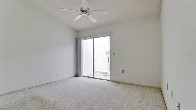 spare room with a textured ceiling, light colored carpet, ceiling fan, and vaulted ceiling