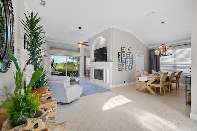 living area featuring light tile patterned floors, ceiling fan with notable chandelier, visible vents, a glass covered fireplace, and crown molding