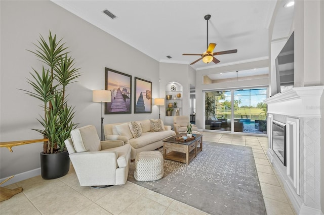 living room with light tile patterned floors, visible vents, ornamental molding, ceiling fan, and baseboards