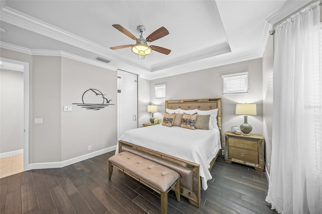 bedroom with crown molding, visible vents, a raised ceiling, and dark wood-style flooring