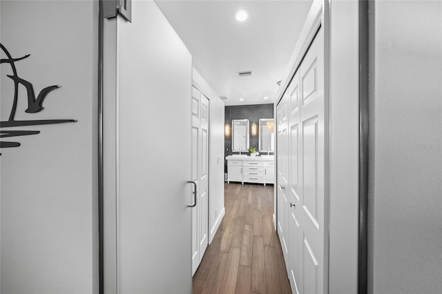 corridor with dark wood-style floors, recessed lighting, and visible vents