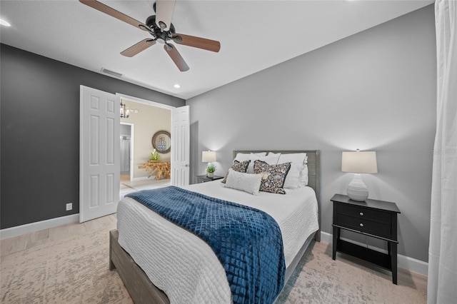 bedroom with light wood finished floors, recessed lighting, visible vents, baseboards, and ceiling fan with notable chandelier