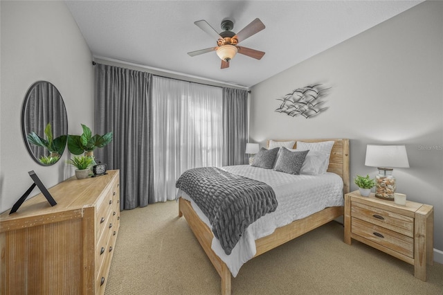 bedroom with a ceiling fan and light colored carpet