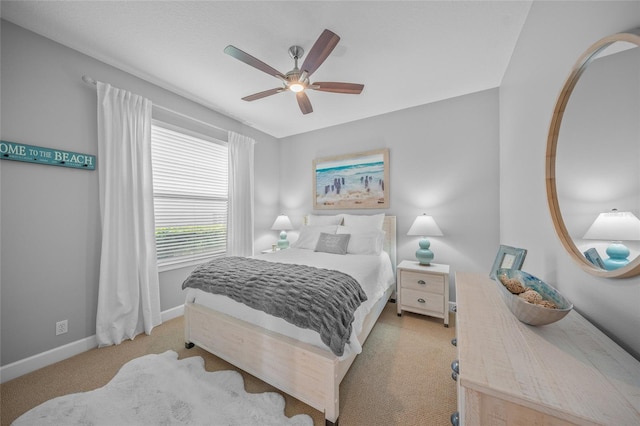 bedroom with light colored carpet, a ceiling fan, and baseboards