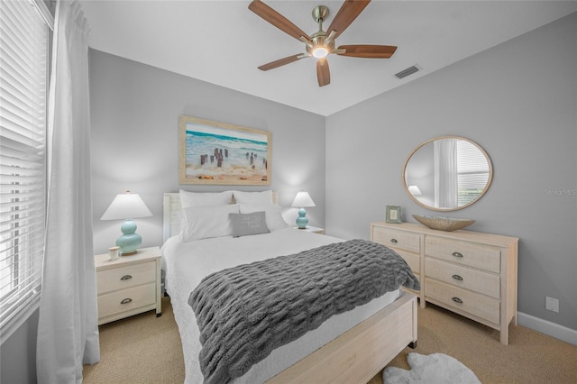 bedroom with light carpet, multiple windows, visible vents, and a ceiling fan