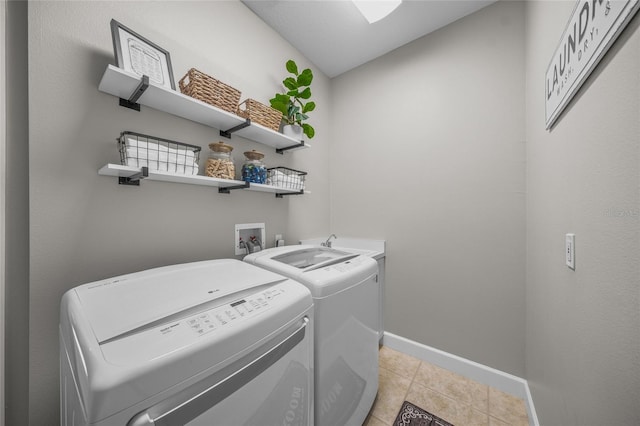 laundry room featuring laundry area, washer and clothes dryer, baseboards, and light tile patterned floors