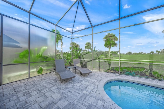 outdoor pool with a patio area and glass enclosure