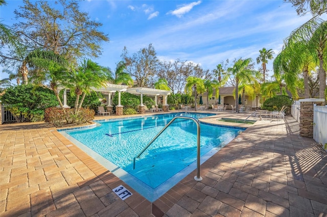 pool with a patio area and a pergola