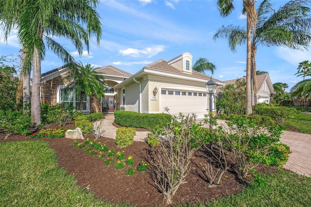 view of front of home with a garage, driveway, and stucco siding