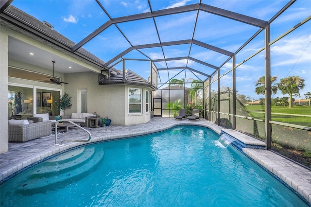 outdoor pool with a ceiling fan, a patio area, glass enclosure, and an outdoor hangout area