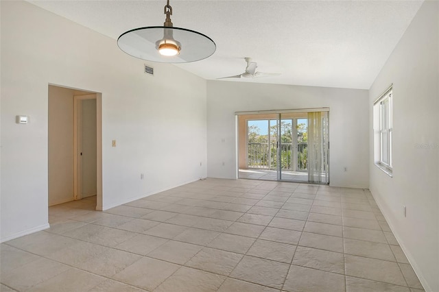 tiled empty room featuring ceiling fan and vaulted ceiling