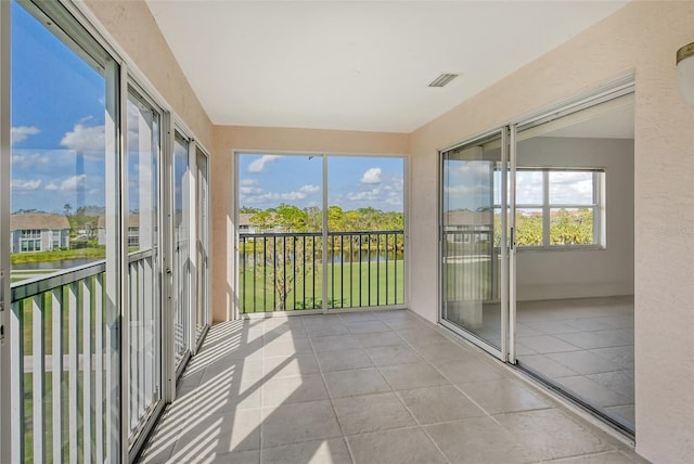 unfurnished sunroom featuring a water view