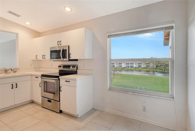 kitchen featuring white cabinets, a water view, sink, and stainless steel appliances