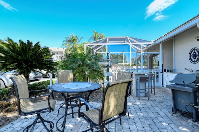 view of patio / terrace with glass enclosure, exterior bar, and grilling area