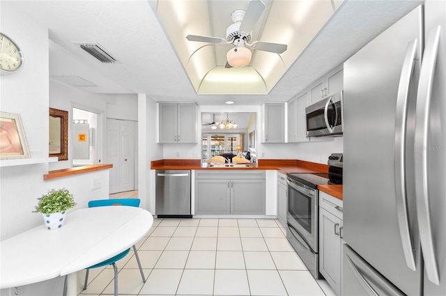 kitchen with sink, appliances with stainless steel finishes, ceiling fan, light tile patterned floors, and gray cabinets