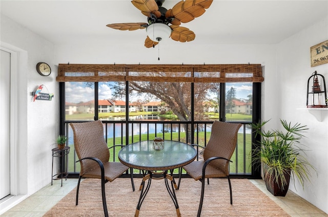 sunroom with a water view and ceiling fan