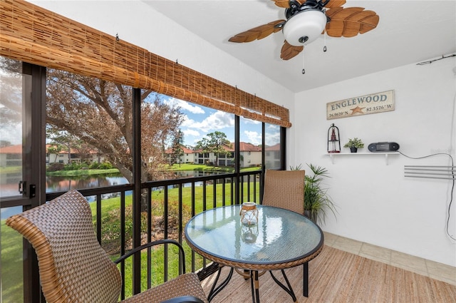 sunroom with a water view and ceiling fan