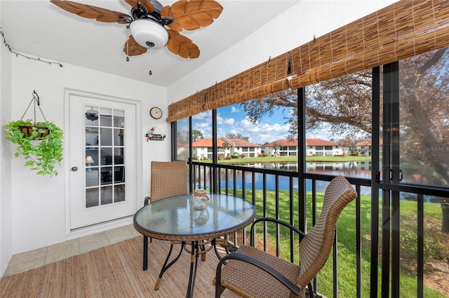 sunroom featuring a water view and ceiling fan