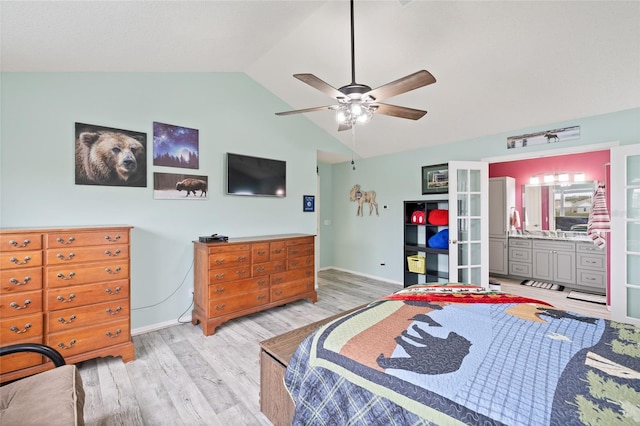 bedroom featuring ensuite bathroom, ceiling fan, light hardwood / wood-style flooring, and vaulted ceiling