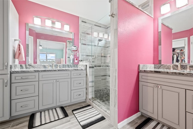 bathroom with hardwood / wood-style flooring, a shower with shower door, and vanity