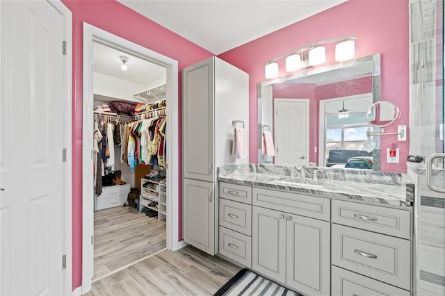 bathroom with vanity, hardwood / wood-style flooring, and ceiling fan