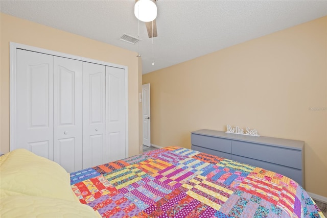 bedroom featuring a textured ceiling, ceiling fan, and a closet